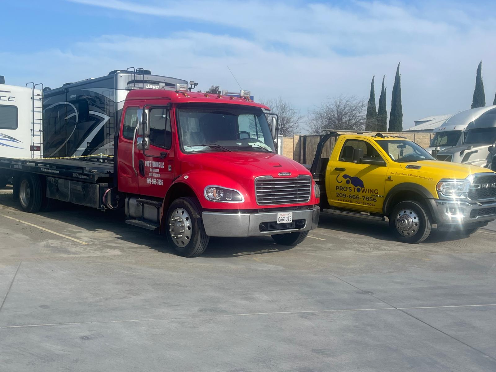 Pro's Towing LLC fleet — red flatbed and yellow service truck ready for roadside assistance